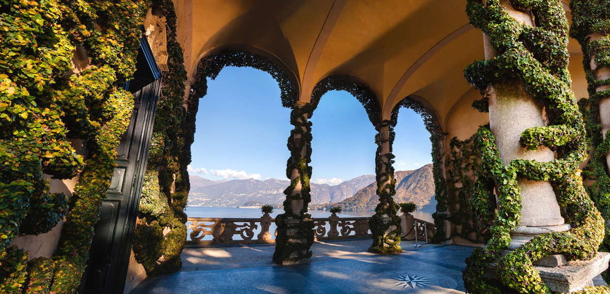 Ivy-covered loggia framing mountain views over Lake Como, Italy