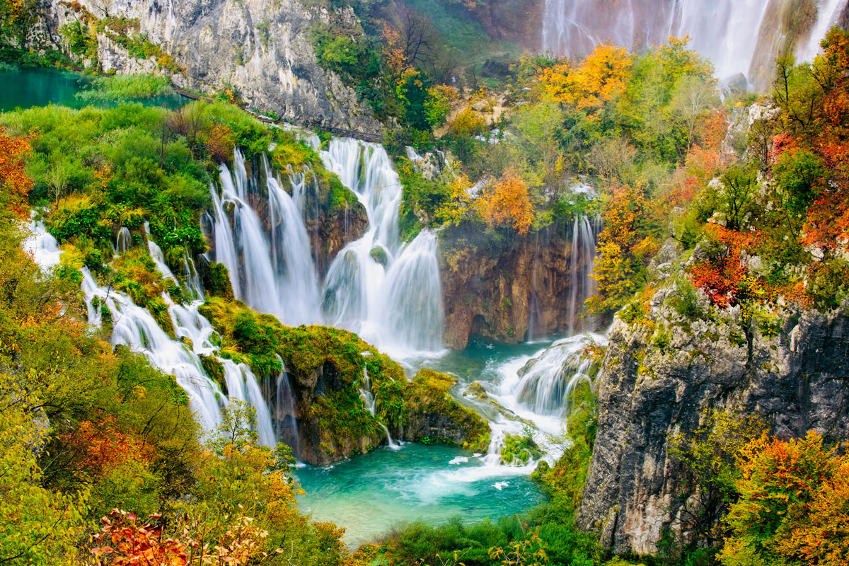 Waterfalls cascading into turquoise pools among autumn trees at Plitvice Lakes, Croatia
