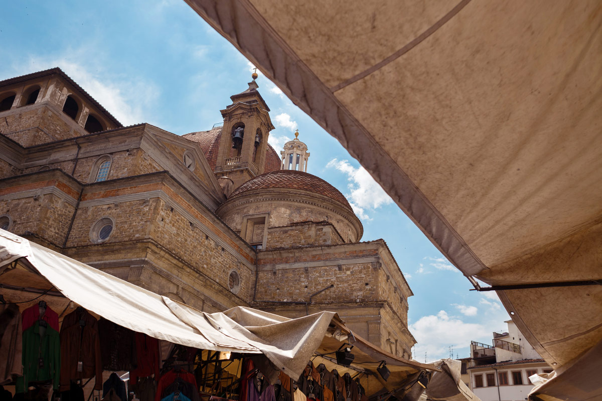 Market stall awnings beneath the Basilica of San Lorenzo dome in Florence, Italy