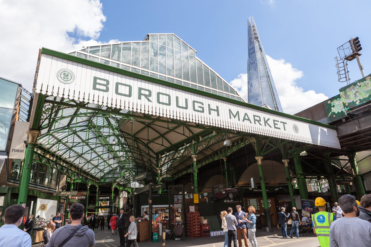 Borough Market's green iron entrance with The Shard rising behind, London