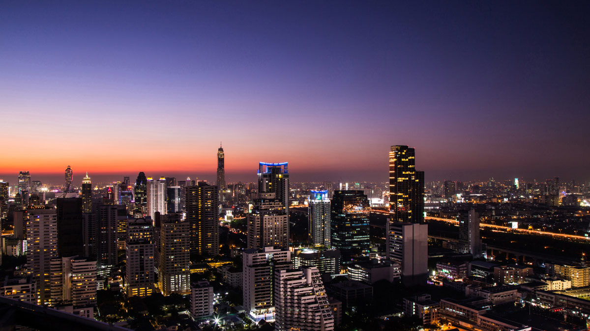 City skyline of high-rise towers lit up at dusk