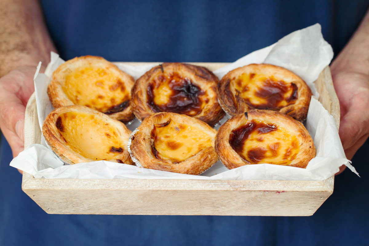 Man holding tray of pasties de nata food bucket list