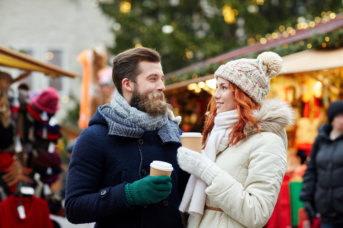 Couple drinking hot chocolate at Christmas Market winter holiday Europe
