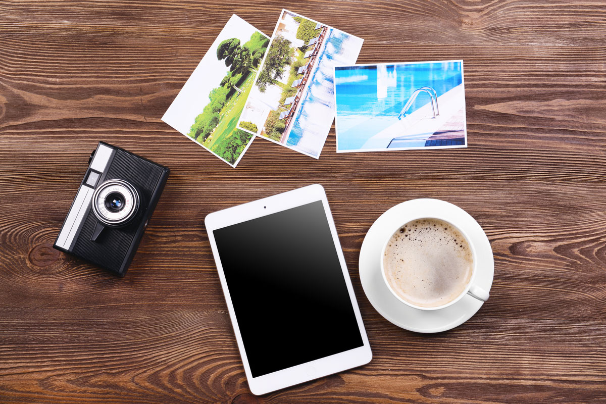 Flat lay of electronics and coffee travel planning