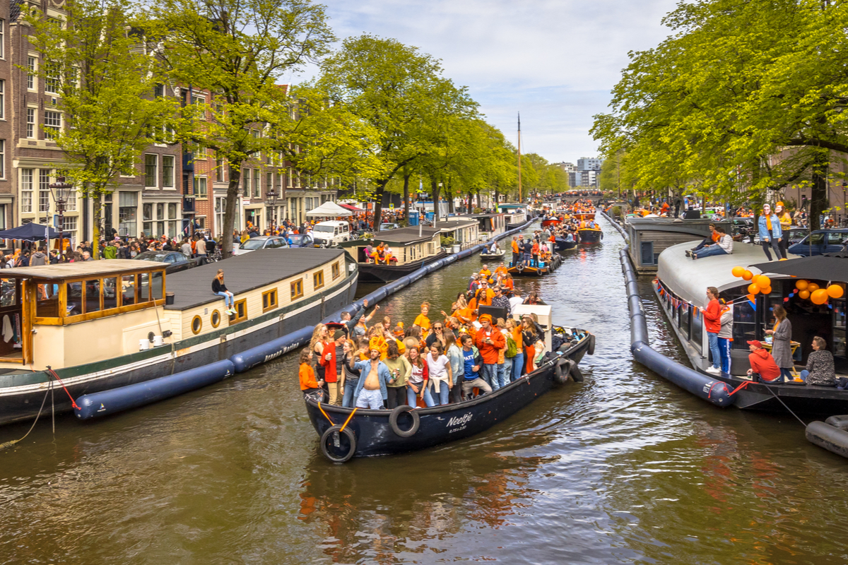 People celebrate on canal boats in Amsterdam King's Day