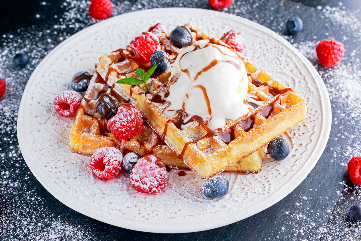 Plate of Belgian waffles woth berries and ice cream World Baking Day