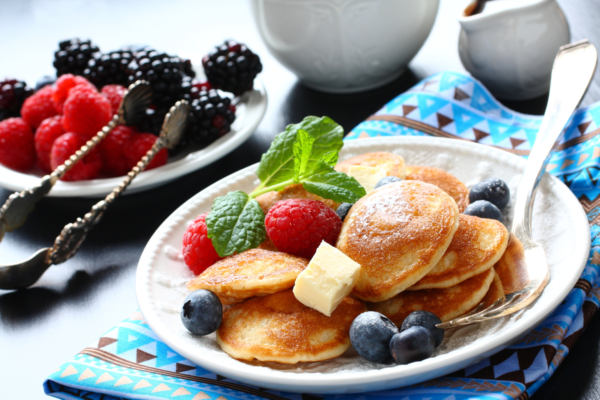 Plate of poffertjes with berries and butter World Baking Day