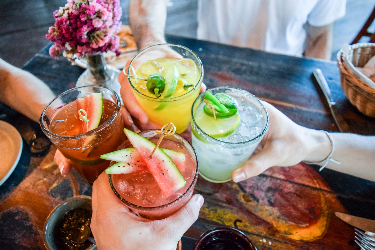 Friends cheers with colourful cocktails