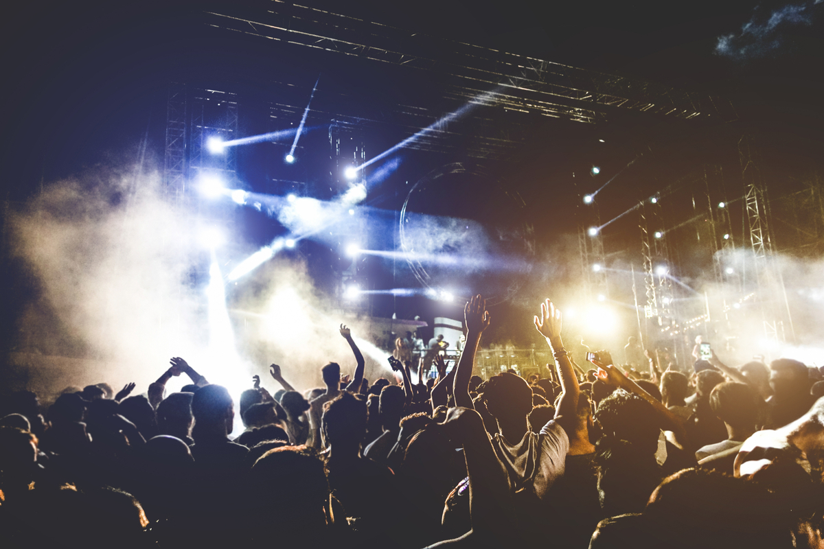 Crowd of people dancing to live DJ music day