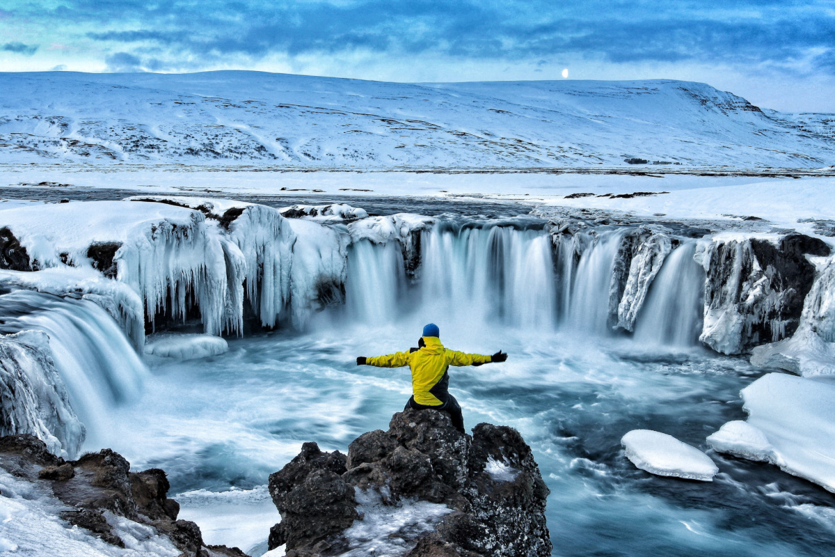 Man hikes to Goðafoss Waterfall in Iceland, World Kindness Day