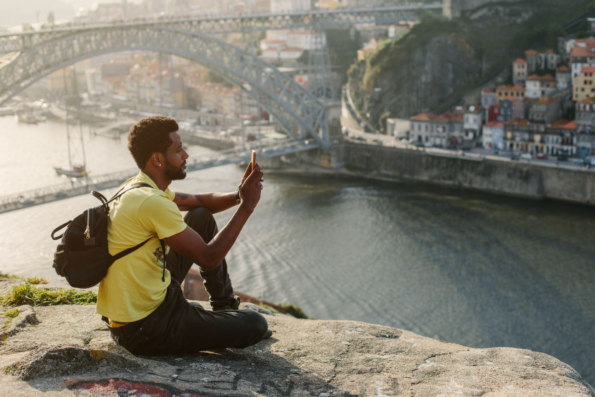 Man uses app while travelling in Portugal, 2023 trends