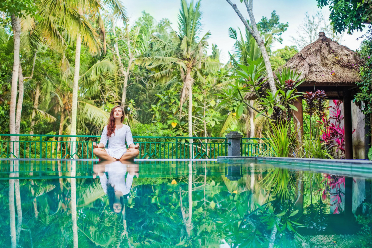 Woman meditating wellness travel, 2023 trends