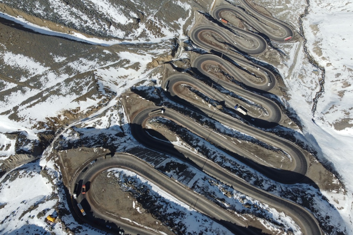 Aerial view of the Los Caracoles hairpin bends through the snowy Andes in Chile