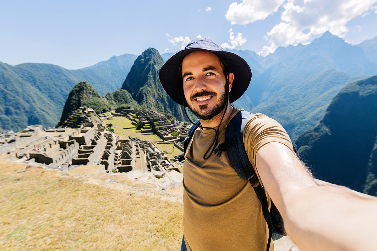 A tourist smiling with Machu Picchu in the background.