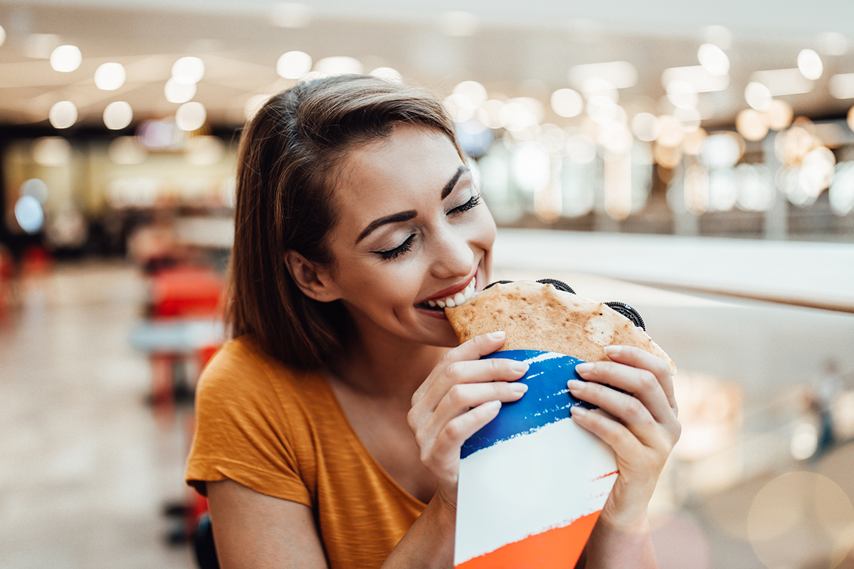 A photo of a lady eating the best crêpes